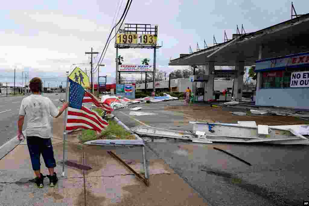 Dustin Amos walks near debris at a gas station on Aug. 27, 2020, in Lake Charles, La., after Hurricane Laura moved through the state.