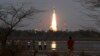 People watch as Indian Space Research Organization’s Geosynchronous Satellite Launch Vehicle Mk III rocket lifts off from the space launch center in Sriharikota, India, June 5, 2017. 