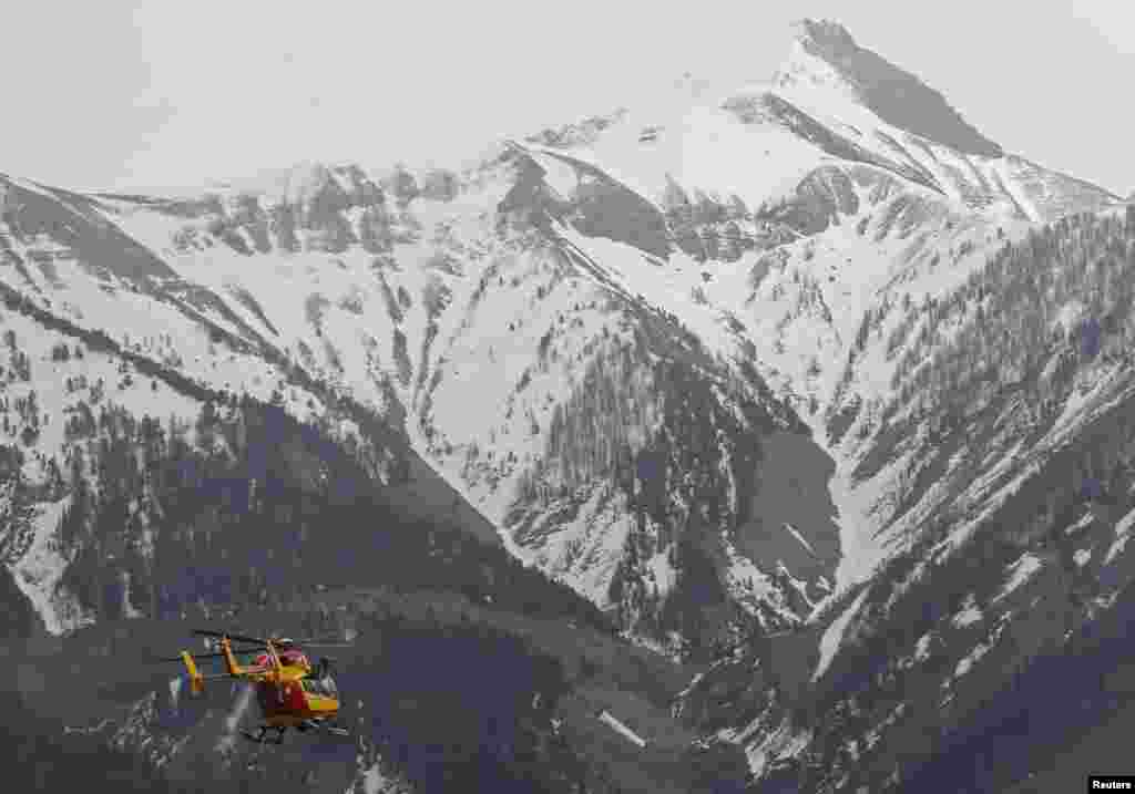 Un hélicoptère de la Sécurité Civile française vole vers les Alpes françaises lors d'une opération de secours près du lieu du crash d'un Airbus A320, près de Seyne-les-Alpes, mardi 24 Mars 2015.