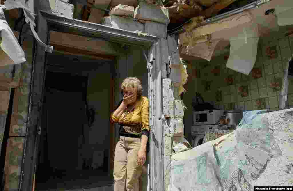 A local woman reacts next to her destroyed home after shelling in pro-Russian rebel-controlled Staromykhaylivka village near of Donetsk, Ukraine, 24 May 2016.