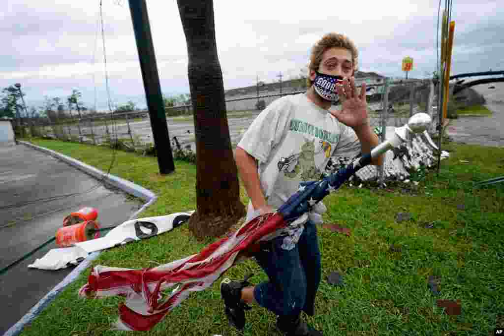 Dustin Amos walks near debris at a gas station on Aug. 27, 2020, in Lake Charles, La., after Hurricane Laura moved through the state.