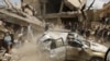 A car falls as it is being lifted by a crane at the site of a Saudi-led air strike in Yemen's capital Sanaa September 21, 2015. 