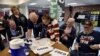 FILE - Voters sign in to cast their ballots during the Nevada Republican presidential caucus at Western High School in Las Vegas, Nevada.