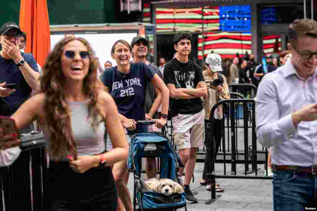 People watch the launch of billionaire American businessman Jeff Bezos and his three crew-mates on Blue Origin's inaugural flight to the edge of space, on a screen in Times Square in New York City.