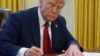President Donald Trump signs a document in the Oval Office at the White House, Jan. 30, 2025, in Washington. 