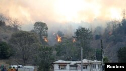 Fire and emergency crew battle bushfire near a house in the rural town of Canungra in the Scenic Rim region of South East Queensland, Australia, Sept. 6, 2019.