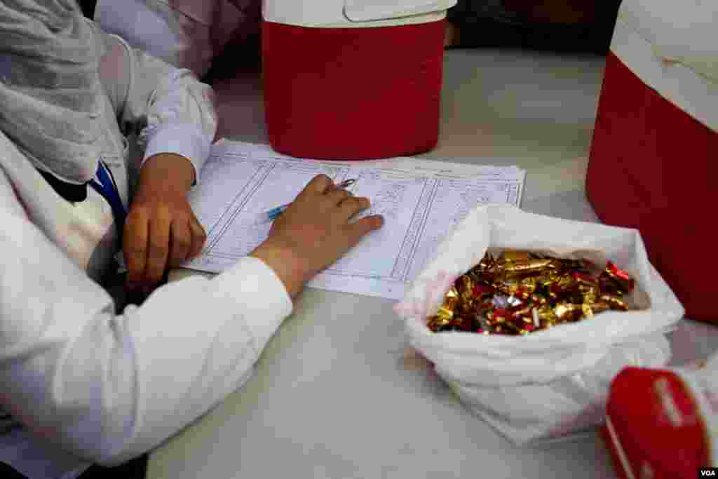 Nurses at a health center handed out candies to children after vaccinating them for polio, Cairo, Nov. 17, 2013. (Yuli Weeks for VOA)