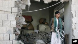 Seorang petugas Yaman tengah berjaga di rum kediaman Dubes Iran di Yaman yang hancur akibat serangan bom mobil di Sanaa, Yaman (3/12).