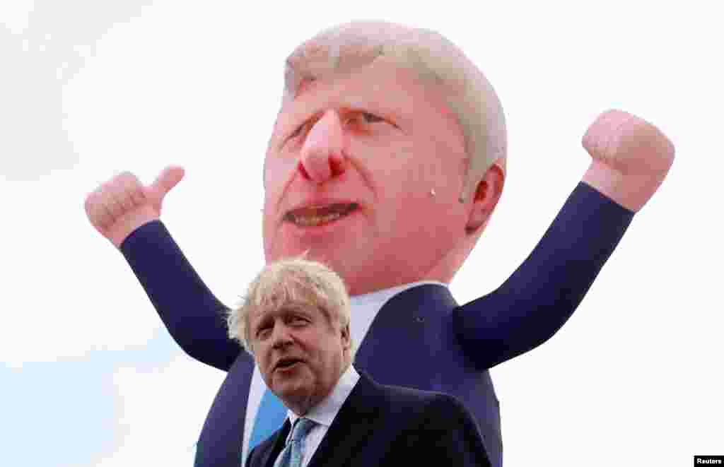 Britain&#39;s Prime Minister Boris Johnson speaks, with an inflatable figure depicting him in the background, following local elections at Jacksons Wharf Marina in Hartlepool, Britain.