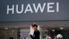 People walk past a Huawei retail store in Beijing, Sunday, June 30, 2019.