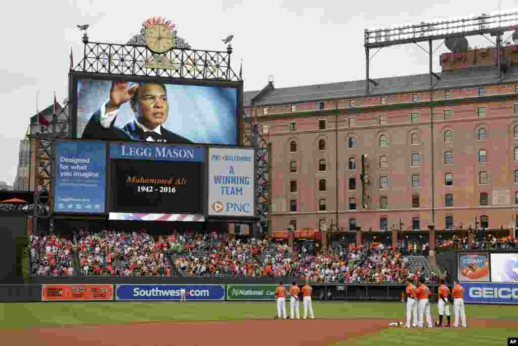 Members of the Baltimore Orioles stand on the field during a moment of silence for boxer Muhammad Ali before a baseball game against the New York Yankees in Baltimore, June 4, 2016. Ali died at age 74.