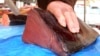 FILE - A fishmonger cuts a joint of Bluefin tuna, which was caught off Thailand, at a stall at the Nice fish market, southeastern France. 