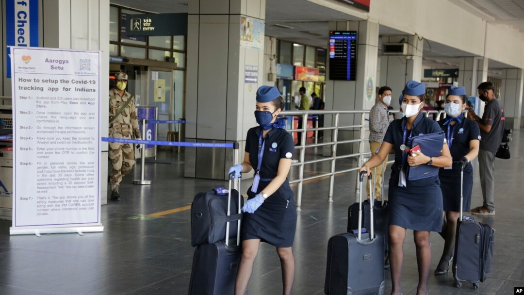 Crew members of an airline arrive at the airport as domestic flights resume operations after nearly two-month lockdown amid the COVID-19 pandemic in Ahmedabad, India, Monday, May 25, 2020. (AP Photo/Ajit Solanki)