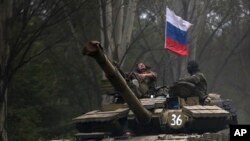 Một thành phần nổi dậy thân Nga ngồi trong chiếc xe tăng treo cờ Nga ở một con đường phía đông Donetsk, 21/7/2014.