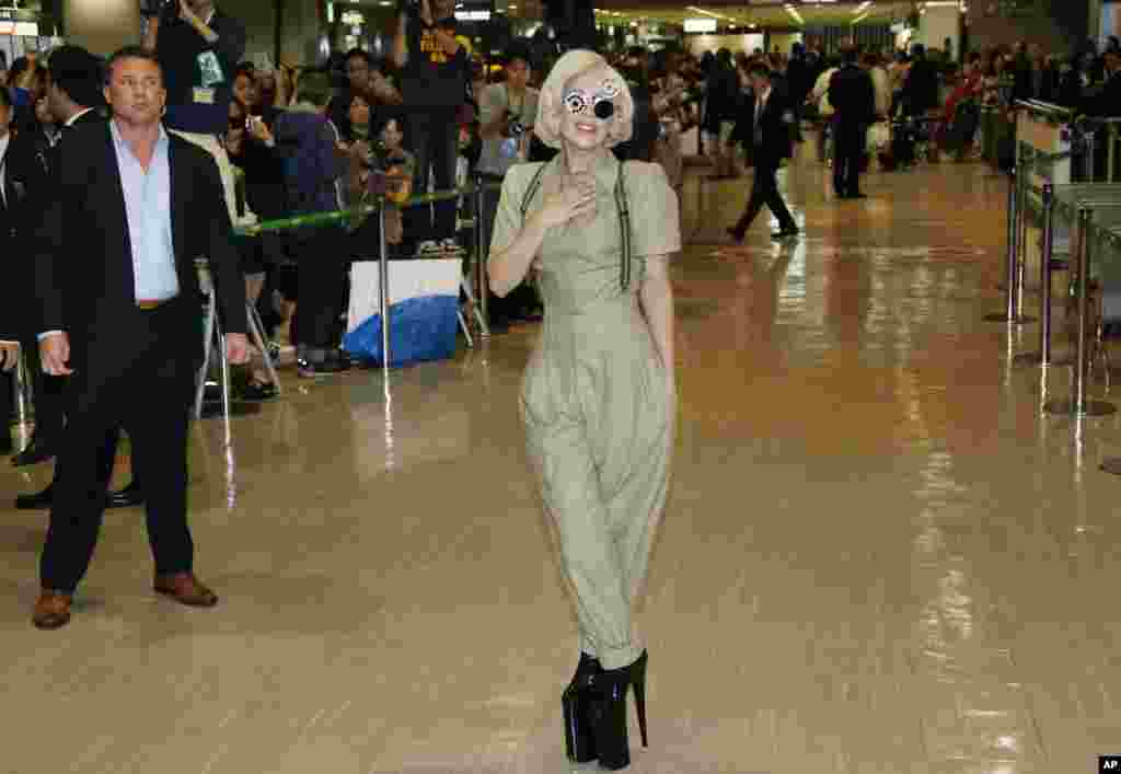 Penyanyi AS, Lady Gaga berpose kepada wartawan saat tiba di bandara Narita, Tokyo. Jepang.