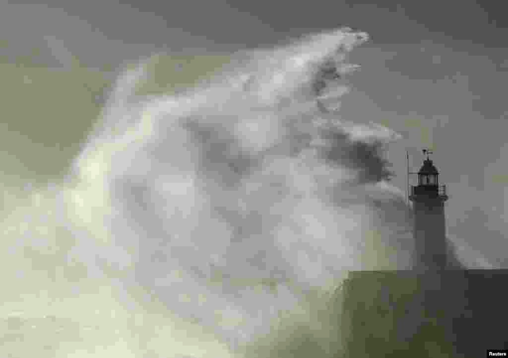 Waves crash against a lighthouse at Newhaven, southeast England, Oct. 28, 2013.