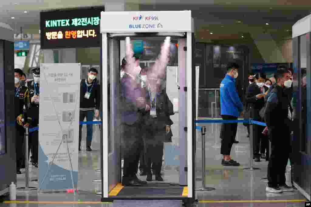 한국 고양시 일산 킨텍스에서 열린 무기 전시회인 &#39;대한민국 방위산업전&#39; 참석자들이 신종 코로나바이러스 방역을 위한 소독 부스를 통과하고 있다. 한국의 일일 신종 코로나바이러스 확진자 수가 3개월만에 또 다시 최다 기록한 가운데 정부는 사회적 거리두기 지침을 강화하고 있다. 