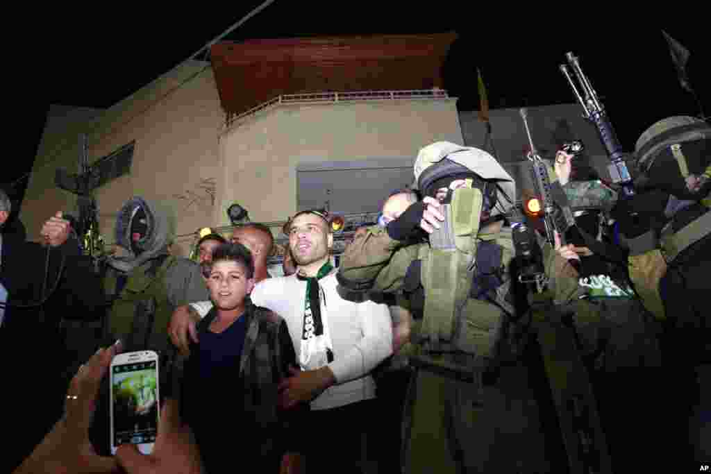 Tahanan Palestina yang dibebaskan, Mohammed Sabbagh, disambut di tempat tinggalnya di kamp pengungsi Jenin di Tepi Barat (30/10). (AP/Mohammed Ballas)
