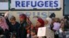 People queue to receive free food at a makeshift camp for migrants and refugees at the Greek-Macedonian border near the village of Idomeni, Greece, April 6, 2016.