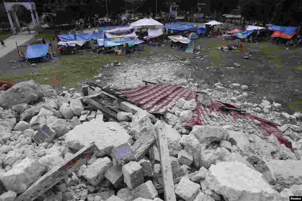 Warga tinggal di tenda pengungsian dekat reruntuhan gereja Our Lady of Light di Loon, Bohol, sehari setelah gempa (16/10).