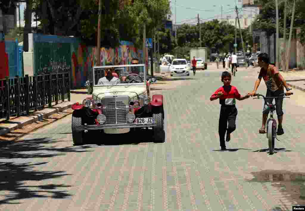 Munir Shindi, a 36-year-old Palestinian, drives a replica of a 1927 Mercedes Gazelle that he built from scratch, on a street in Gaza City, June 19, 2016.