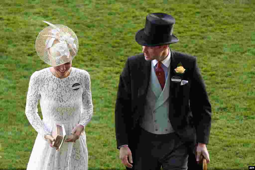 Britain's Prince William, Duke of Cambridge, (L) and Britain's Catherine, Duchess of Cambridge, (R) walk together as they attend the second day of the Royal Ascot horse racing meet in Ascot, west of London.