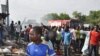 People gather at the scene of a car bomb explosion, at the central market, in Maiduguri, Nigeria, July 1, 2014. They immediately blamed Boko Haram, the Islamic extremist group, whose birthplace is Maiduguri.