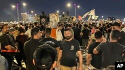 Para pengunjuk rasa berkumpul di Lapangan Tahrir Bagdad, membawa bendera Irak dan gambar ulama Syiah Irak yang berpengaruh dan pemimpin politik Muqtada al-Sadr, Sabtu, 22 Juli 2023.