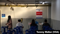 Petugas medis memberikan alat tes COVID-19 kepada pasien di Rumah Sakit Thonburi Bamrungmaung, Bangkok, Thailand, 24 Februari 2022. (Tommy Walker/VOA)