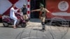 Indian paramilitary soldiers question a person on a scooter before letting him pass at a barbed-wire road checkpoint set up by Indian security forces in Srinagar, Indian-controlled Kashmir, July 7, 2017. 