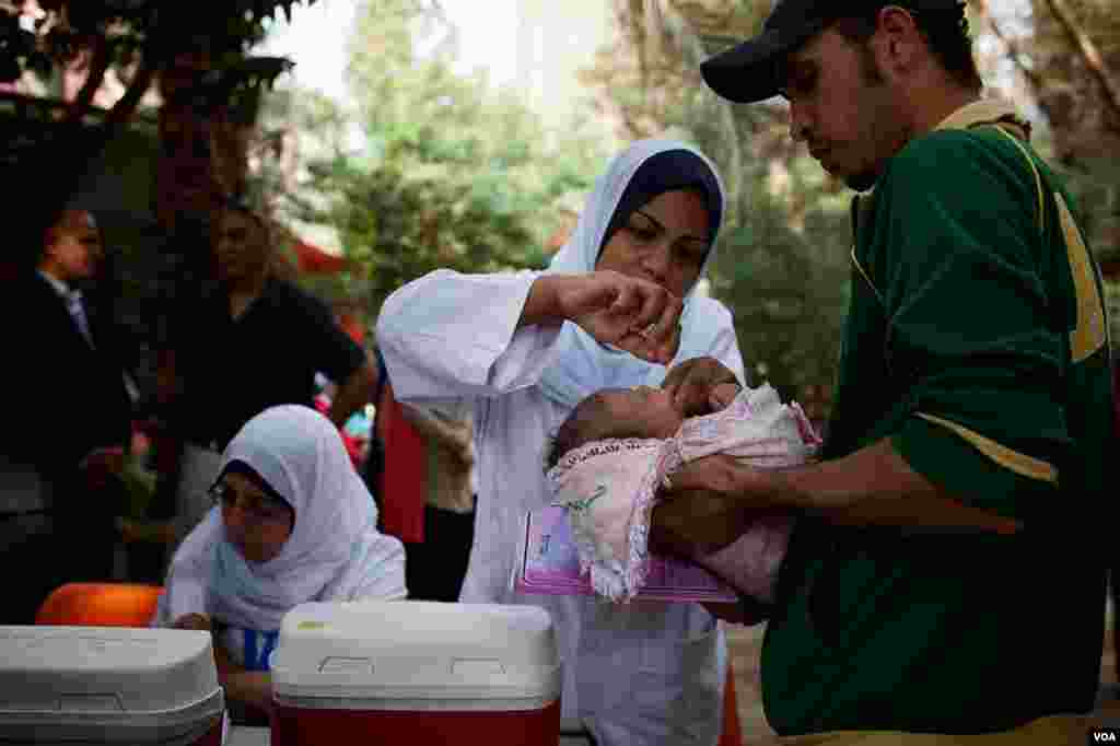 Anxious parents lined up across the capital as Syria's polio outbreak brought Egypt's immunization campaign new urgency, Cairo, Nov. 17, 2013. (Yuli Weeks for VOA)