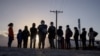 FILE - Asylum-seeking migrants from Central America await transport after crossing the Rio Grande River into the United States from Mexico on a raft in Penitas, Texas, March 12, 2021. 