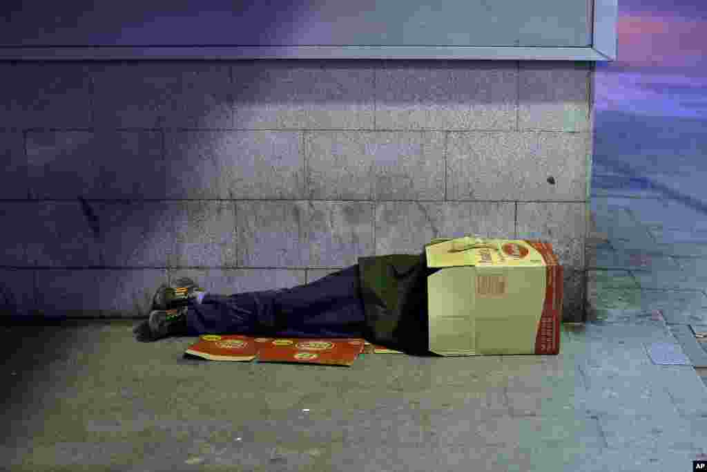 Seorang pria tidur di dalam sebuah kotak kardus di kota Madrid, Spanyol. Tingkat pengangguran di Spanyol masih cukup tinggi sekitar 26 persen.