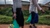 FILE - Sex workers walk home after receiving aid during a lockdown to fight COVID-19 in Kampala, Uganda, May 7, 2020. A bill passed in the first week of May 2021 would enshrine criminalization of same-sex relations, sex work and those living with HIV. 