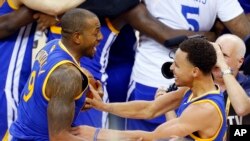 Photo d'archives: Stephen Curry, à droite, et Andre Iguodala de Golden State Warriors célébrant leur victoire à l’issue du match 6 comptant pour la finale de la NBA à Cleveland, mardi 16 juin 2015.