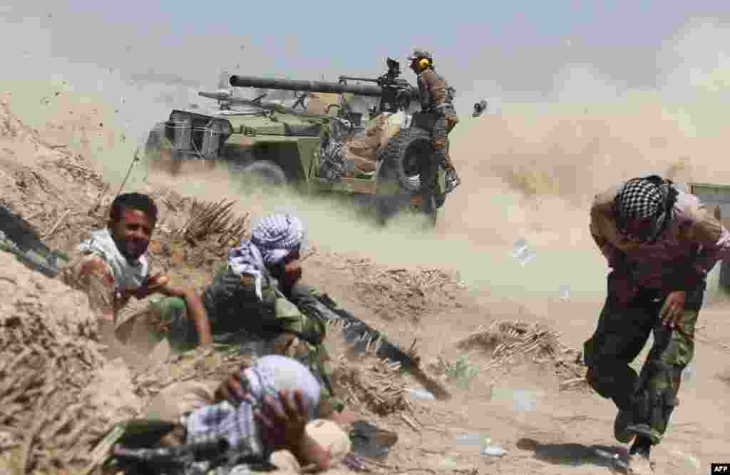 Iraqi government forces fire an anti-tank cannon near al-Sejar village, northeast of Fallujah, as part of a major assault to retake the city from the Islamic State group, May 25, 2016.
