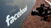 FILE - A television photographer shoots the sign outside of Facebook headquarters in Menlo Park, Calif., May 18, 2012.