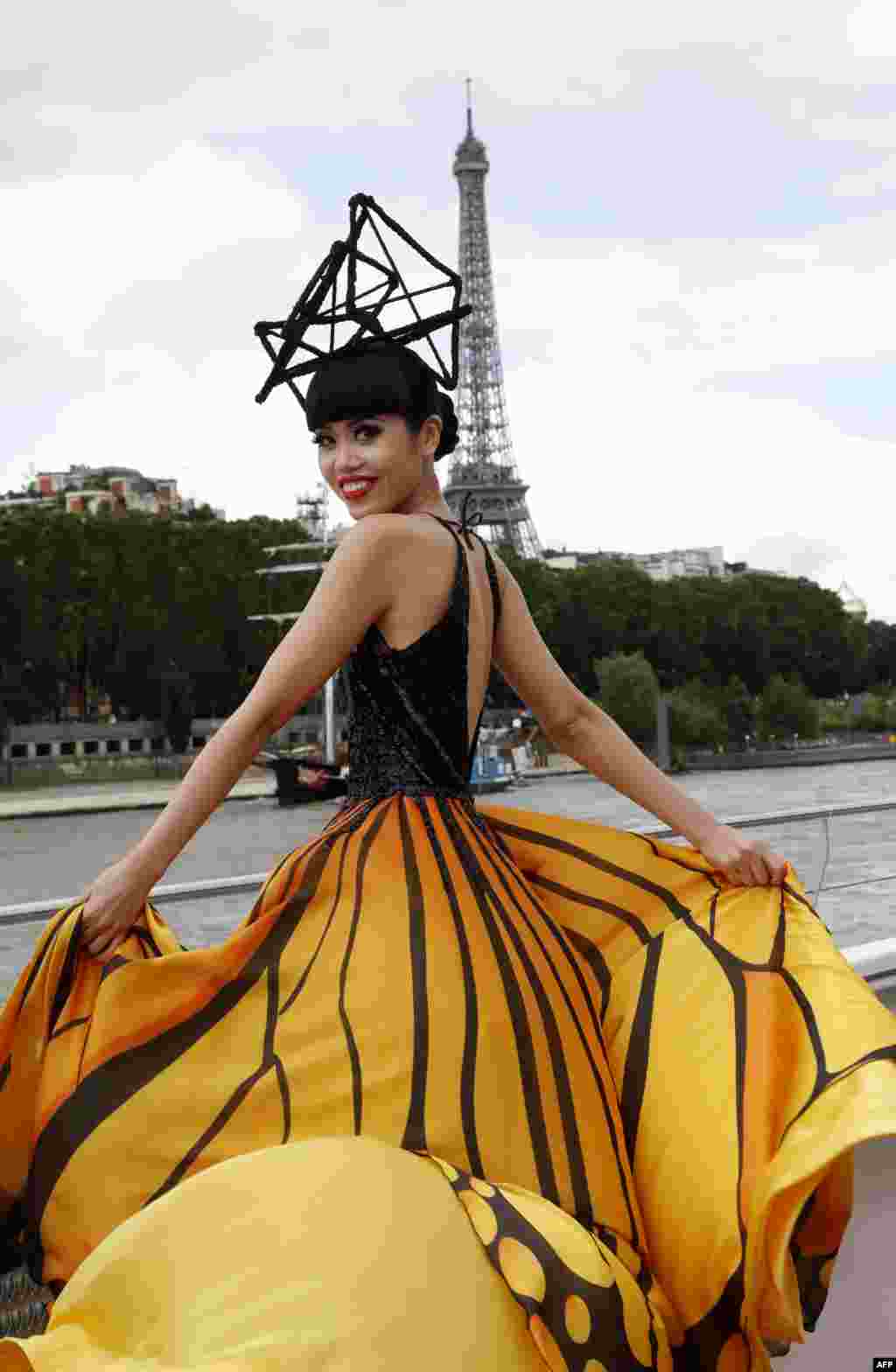 Vietnamese fashion show organiser, producer and model Jessica Minh Anh presents a creation during a fashion show on a tourist river boat cruising the Seine, as part of the J Autumn Fashion Show 2016 near the Eiffel Tower in Paris.