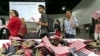 FILE - Immigrants pick flags as they arrive to take their citizenship oath during naturalization ceremonies at a U.S. Citizenship and Immigration Services (USCIS) ceremony in Los Angeles.