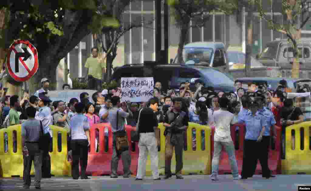 A woman protests outside the Jinan Intermediate People's Court in Jinan, eastern China's Shandong province, August 21, 2013.