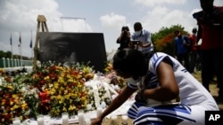 Une femme allume une bougie à un mémorial à l'extérieur du palais présidentiel à la mémoire du président assassiné Jovenel Moise, à Port-au-Prince, Haïti, le 14 juillet 2021.