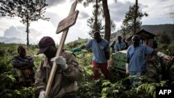 FILE - Health workers carry a coffin containing a victim of Ebola virus on May 16, 2019 in Butembo.