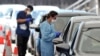 Health officials collect COVID-19 swab tests at a drive-through testing site on Bondi beach in Sydney on Dec. 15, 2021, as rapidly-growing Omicron and Delta clusters brought more than 2,700 new cases nationally. 
