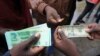 FILE: Bathengiselana imali emgwaqweni eZimbabwe. (AP Photo/Tsvangirayi Mukwazhi)
