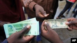 FILE: Bathengiselana imali emgwaqweni eZimbabwe. (AP Photo/Tsvangirayi Mukwazhi)