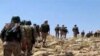 FILE - This frame grab from video released July 22, 2017, and provided by the government-controlled Syrian Central Military Media, shows Hezbollah fighters advancing up a hill in an area on the Lebanon-Syria border.