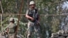 Indian army soldiers keep guard on top of a shop along a highway on the outskirts of Srinagar, Sept. 29, 2016. 
