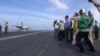 US Secretary of Defense Ash Carter (center, in blue shirt) watches a jet take off from the USS John C. Stennis in the South China Sea (C.Babb/VOA)