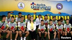 FILE - The 12 boys and their soccer coach who were rescued from a flooded cave arrive for a news conference in the northern province of Chiang Rai, Thailand, July 18, 2018. 