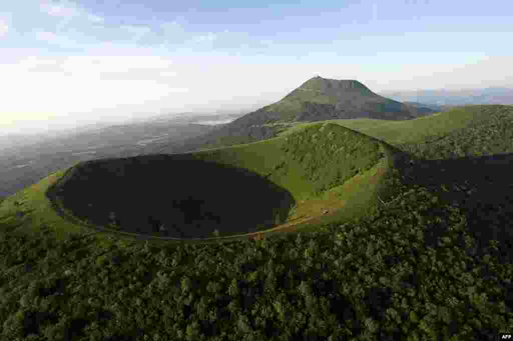 Sebuah foto menunjukkan Chaine des Puys, rangkaian dari 80 gunung berapi yang berada dalam jarak 32 km, dengan Puy de Dome (atas) dan Puy de Pariou (bawah) di dekat Clermont-Ferrand. Komite warisan dunia akan memutuskan pada tanggal 21 Juni 2014 apakah Chaine des Puys akan masuk dalam daftar Situs Warisan Dunia UNESCO.